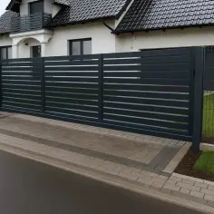 Nowoczesna, ciemnoszara brama wjazdowa z poziomymi szczebelkami. Określenie jaka szerokość bramy wjazdowej jest kluczowa dla funkcjonalności.
