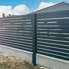 Nowoczesne ogrodzenie z poziomych paneli, co zamiast podmurówki pod ogrodzenie? Betonowy cokół stanowi solidną podstawę.