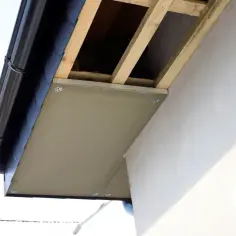 Drewniany stelaż podbitki dachowej, widoczny pod czarnym rynna, gotowy do montażu.
