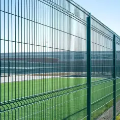 Zielona siatka ogrodzeniowa na boisku sportowym. Świetny pomysł na tanie ogrodzenie działki, trwałe i estetyczne.