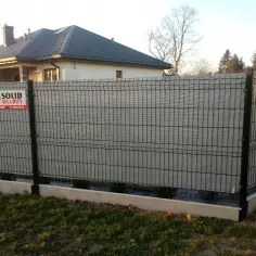 Solidny płot z siatki ogrodzeniowej zabezpiecza posesję. Na słupku widoczny znak "SOLID SECURITY".
