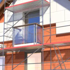 Dom w trakcie ocieplania. Rusztowanie wokół budynku, widoczne białe panele elewacyjne i cegła. Zastanawiasz się, jaki styropian na ocieplenie domu będzie najlepszy?