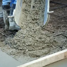 Wylewanie świeżego betonu na zbrojenie. Grunt do betonu przygotowany do pracy.