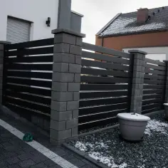 Nowoczesne ogrodzenie z czarnych paneli i betonowych słupków. Jaka wysokość ogrodzenia od sąsiada? To około 1,5 metra.