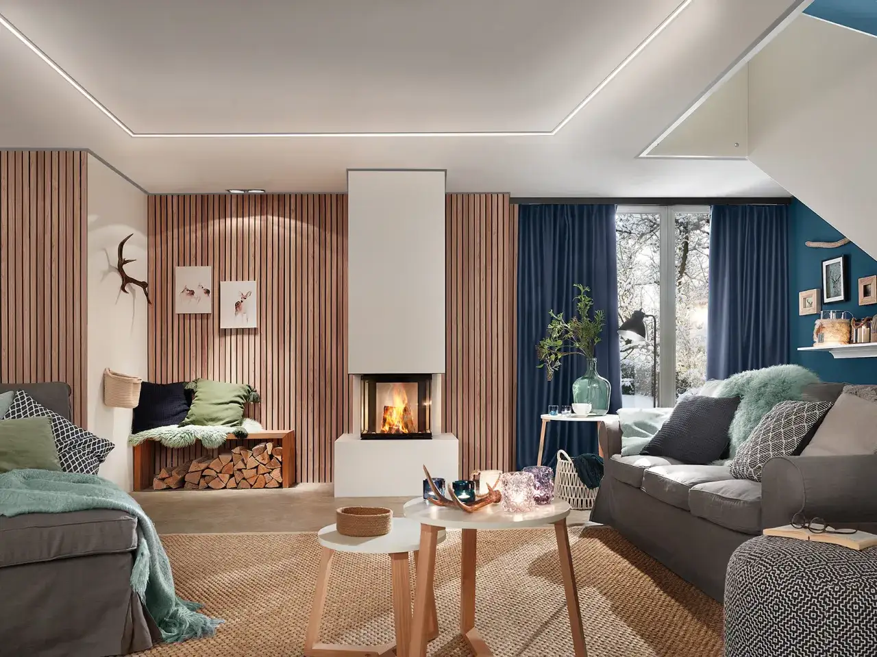 Nowoczesny salon z kominkiem, który inspiruje, jak wykończyć kominek. Drewniane panele, wygodne sofy i zimowy widok za oknem tworzą przytulną atmosferę.