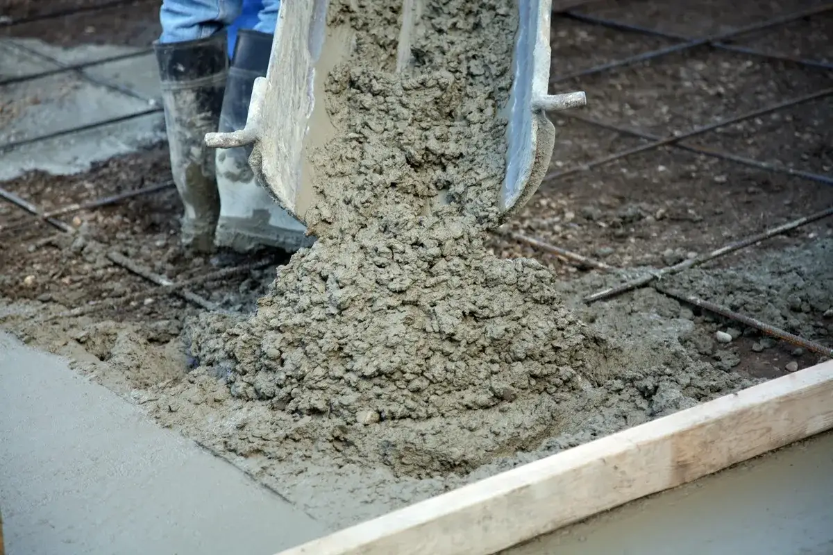 Świeży beton wylewany z betoniarki na zbrojenie. Grunt do betonu przygotowany do pracy.