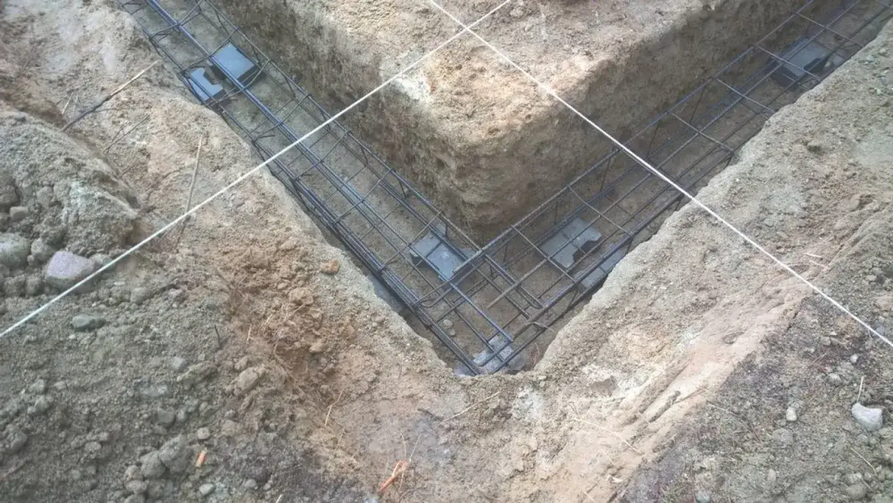 Gotowe zbrojenie na fundamenty w wykopie. Stalowe pręty tworzą siatkę, która wzmocni beton.