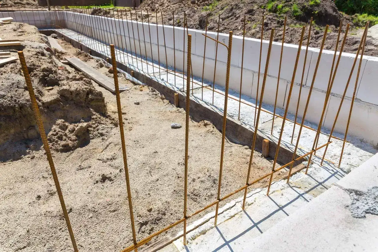Przygotowanie zbrojenia na fundamenty. Stalowe pręty tworzą siatkę, która wzmocni przyszły beton.