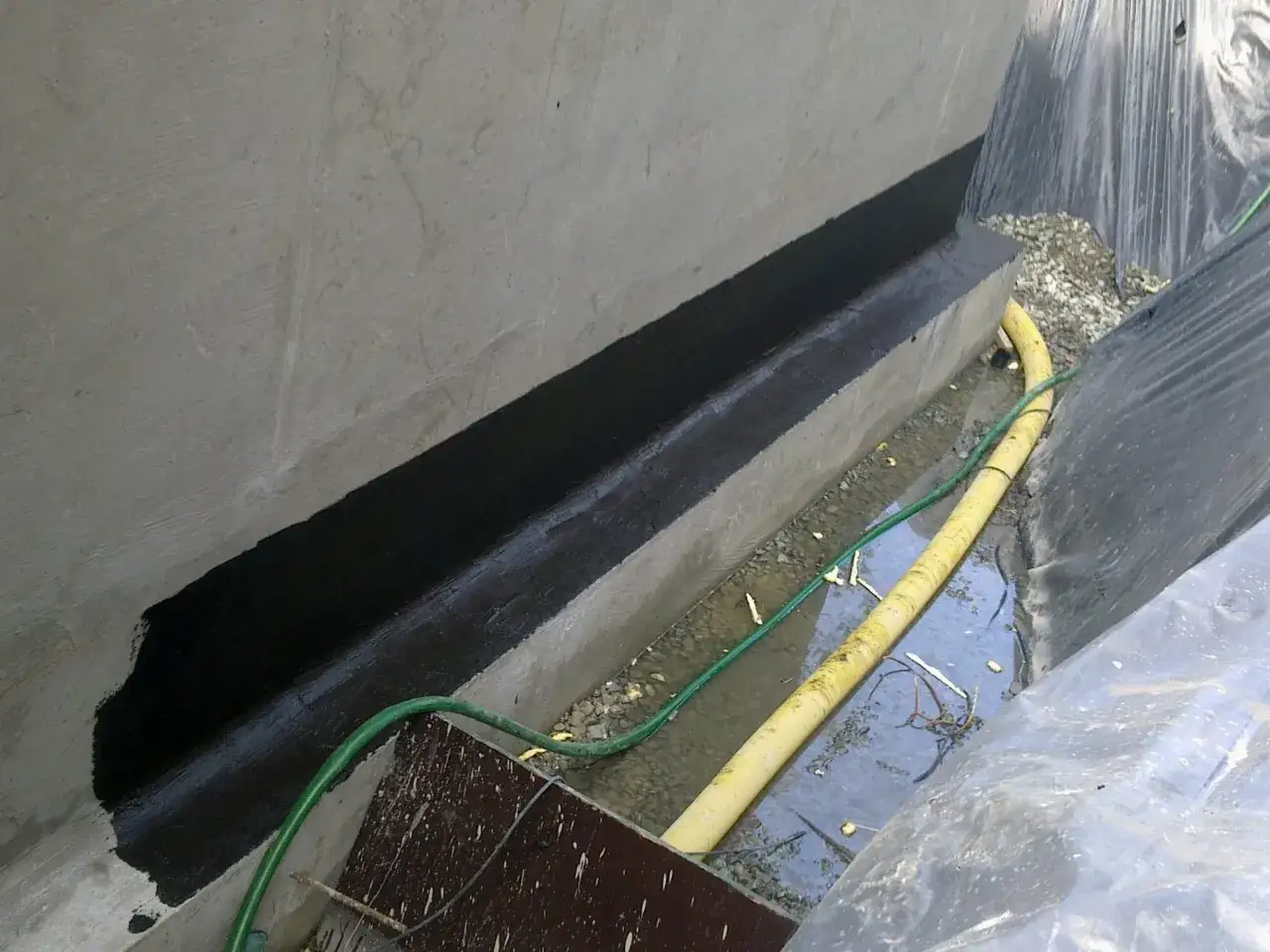 Wykonano hydroizolację ścian fundamentowych. Czarna masa zabezpiecza beton przed wilgocią.